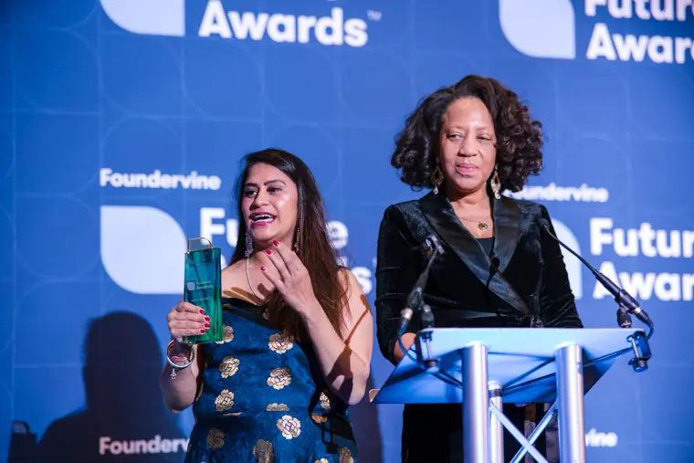 Two presenters introduce an award together.