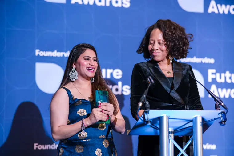 Presenters show an award to the audience.