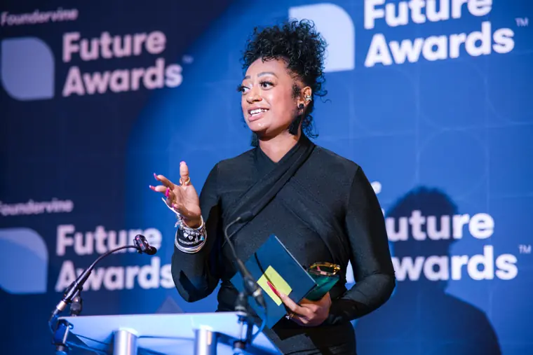 A recipient speaks while holding an award.