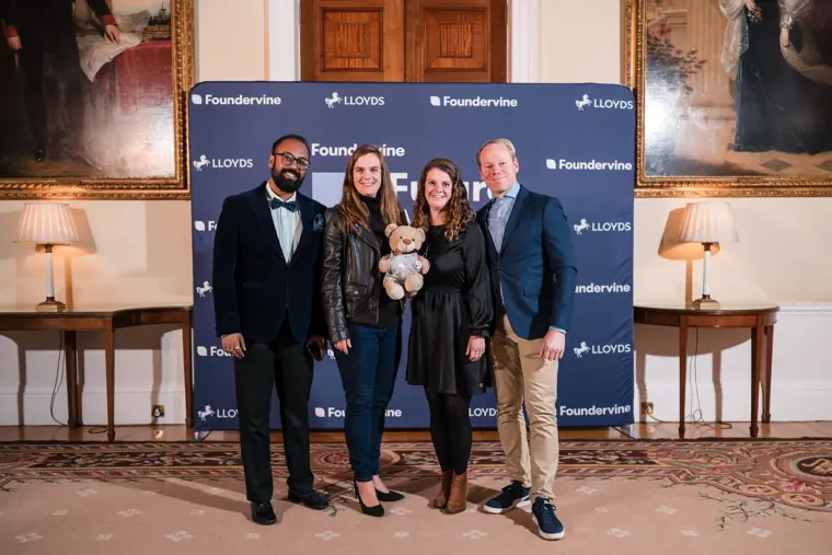 A group of guests pose at the awards photo wall.