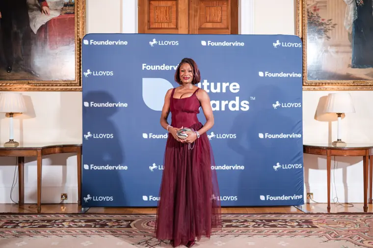 A guest poses beside the Future Awards backdrop.