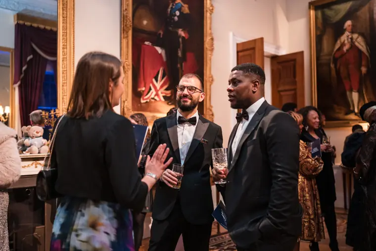 Three guests talk together at the reception.