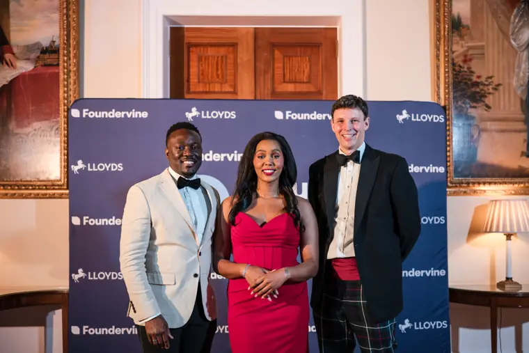 Guests pose for a group photograph at the photo wall.