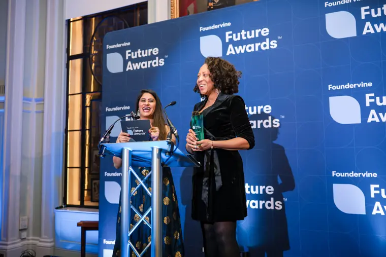 Presenters announce an award on stage.