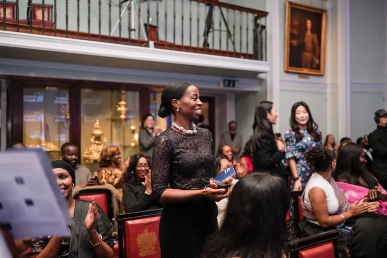 A guest stands to applaud from the audience.