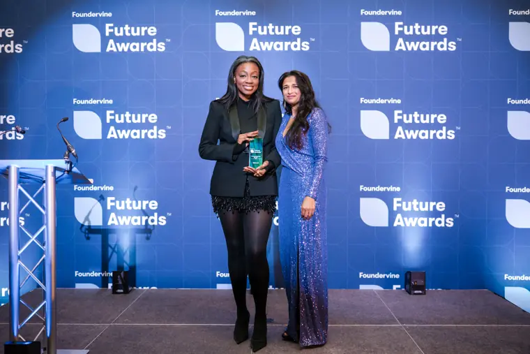 Two people pose with a Future Awards trophy.