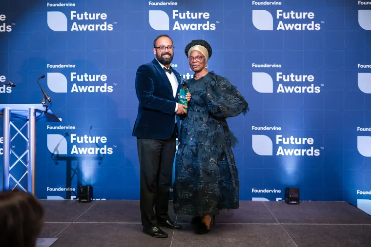 A presenter and recipient pose with an award.