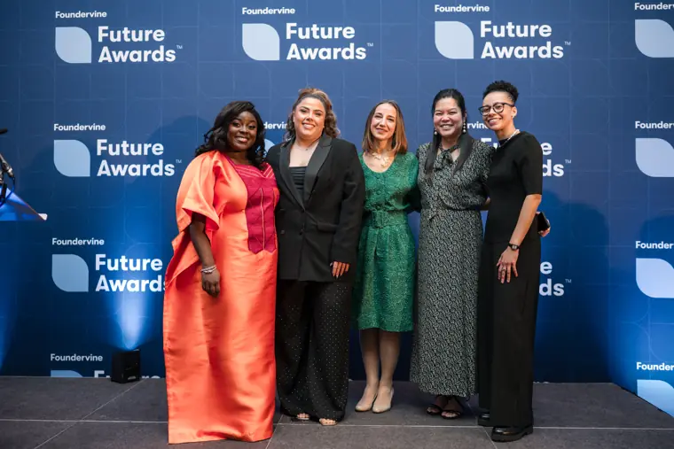 A group of guests poses against the blue backdrop.