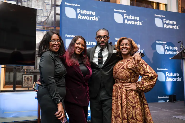 Three guests share a portrait at the awards backdrop.