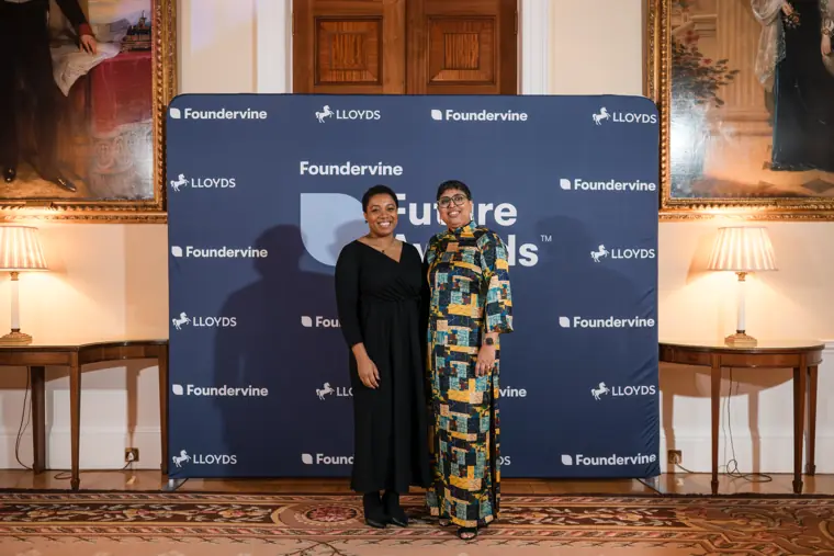 A presenter and recipient pose together with an award.