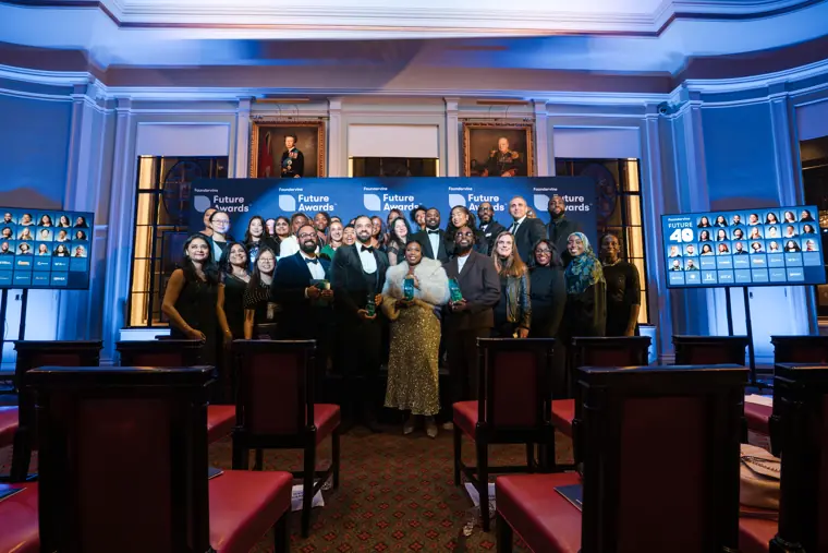 Award recipients and organisers pose together on stage.