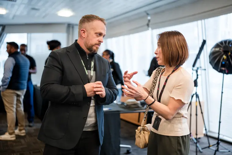 Two attendees talk between showcase sessions.