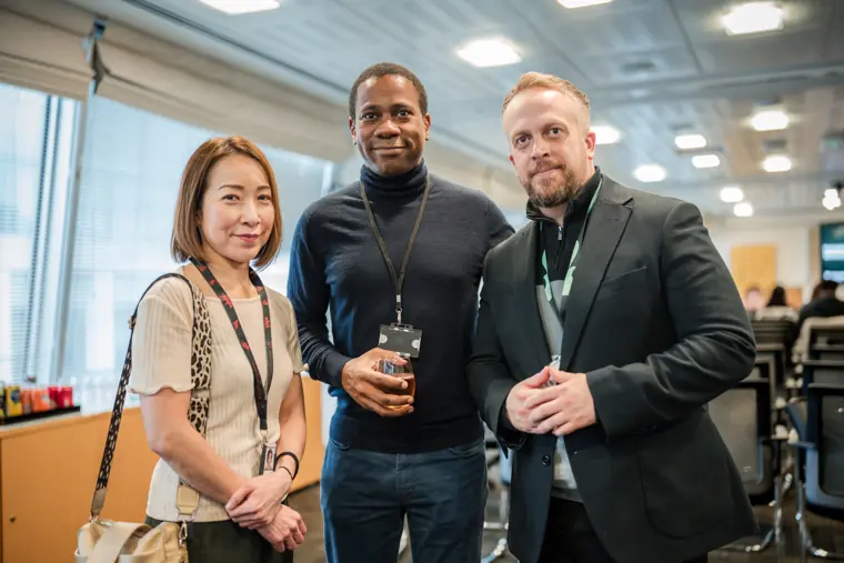 Three guests pose together in the networking area.