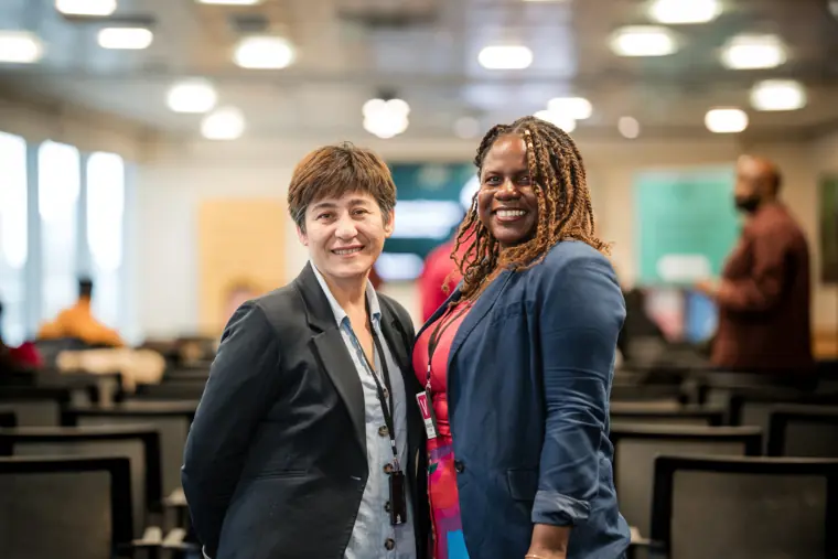 Two attendees smile for a portrait after a pitch.