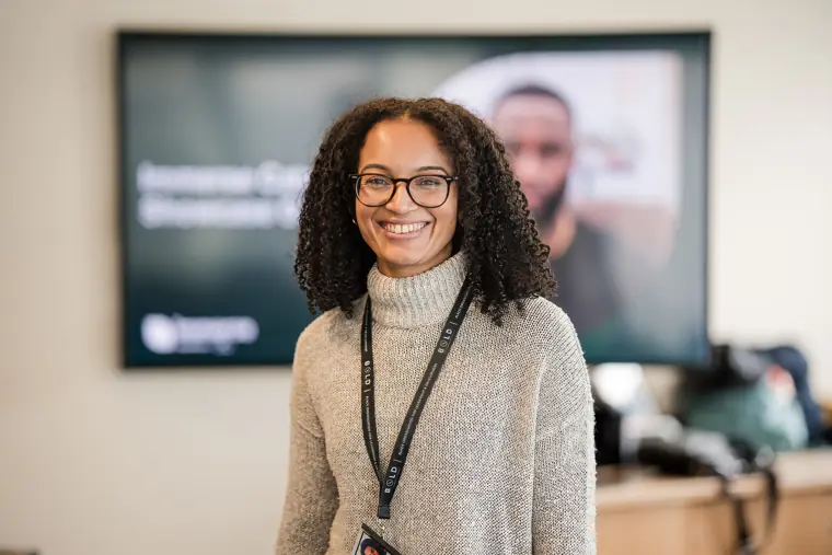 A guest poses for a portrait with the showcase screen behind her.