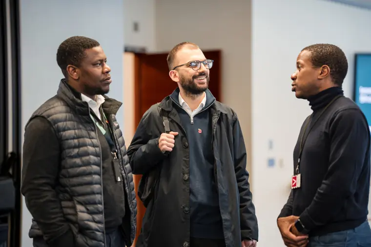 Three guests talk during the networking break.