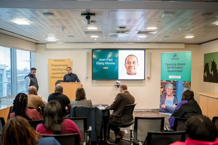 A wide view of the speaker and audience.