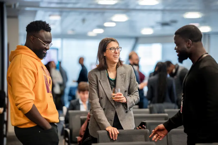 Three guests speak together during networking.