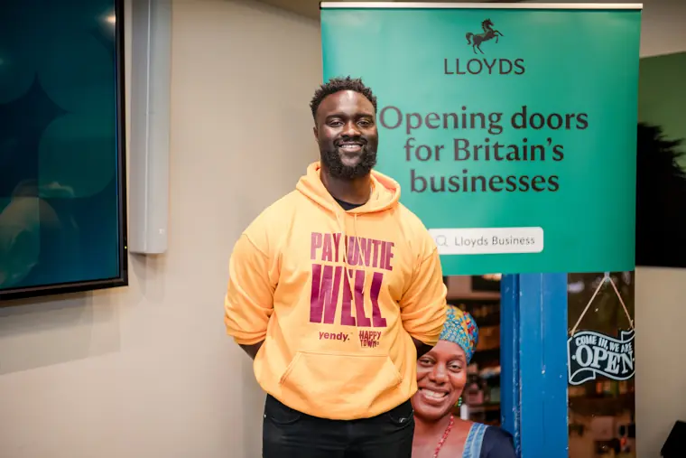 A founder stands for a portrait by the Lloyds banner.