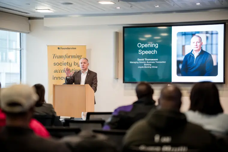 A wide view of a presentation and the seated audience.