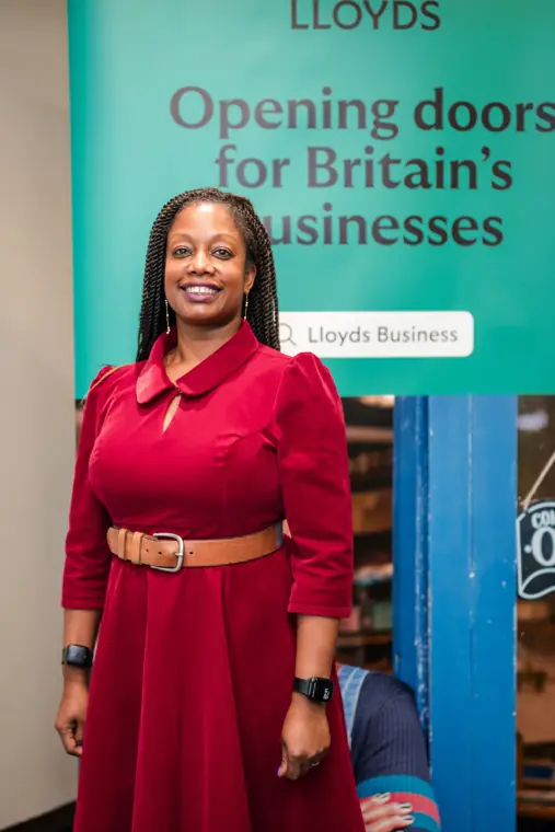 A founder poses beside the Lloyds business banner.