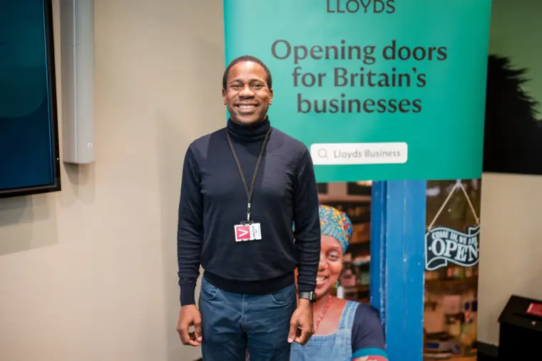 A founder poses for a portrait in front of the Lloyds backdrop.
