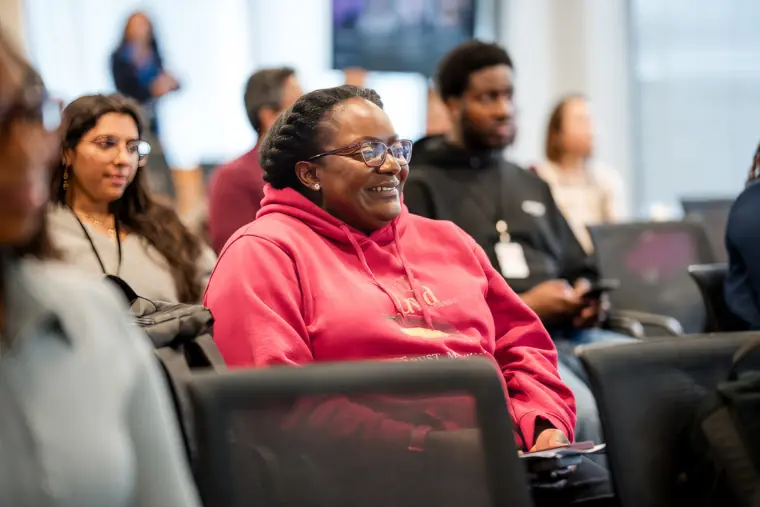 An audience member smiles during a founder pitch.