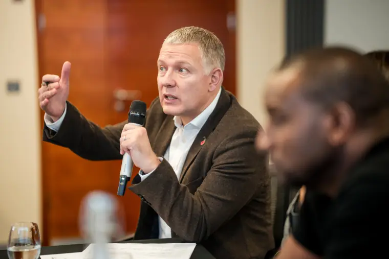 A judge speaks into the microphone during a founder pitch.