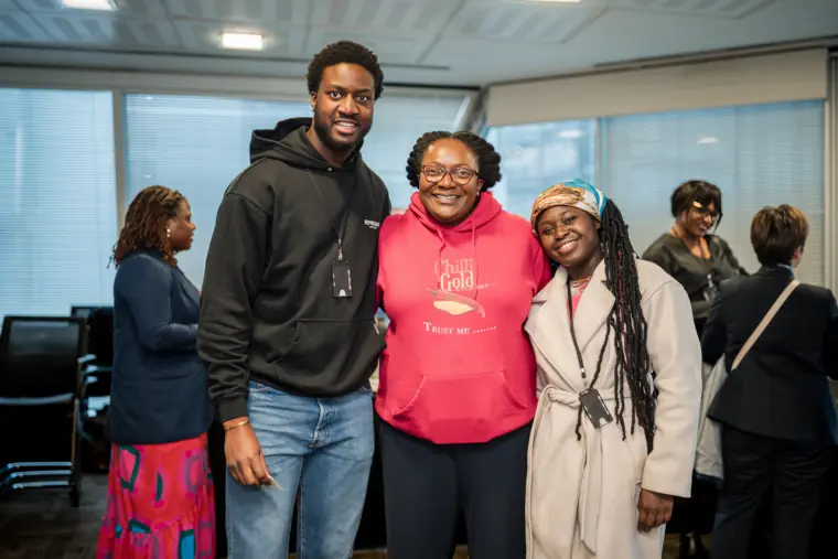 Three guests smile for a group photograph after the programme.