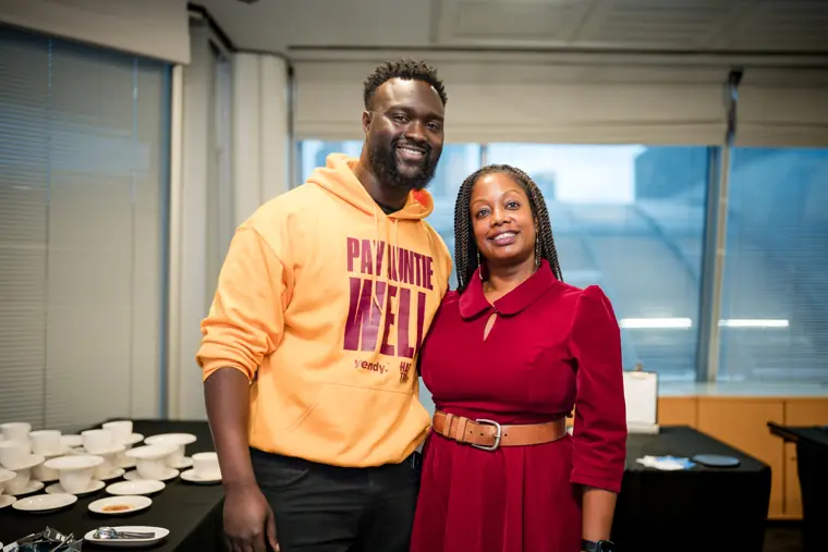 Two participants pose beside the refreshments table.