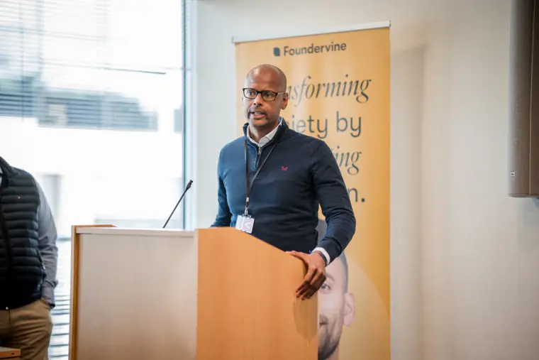 A presenter speaks beside the Foundervine banner.