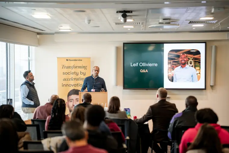 A wide view of a founder pitching to the room.