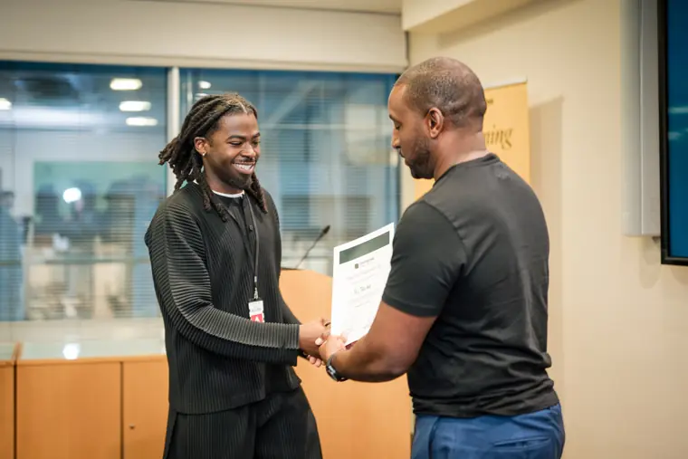 A founder receives a certificate on stage.