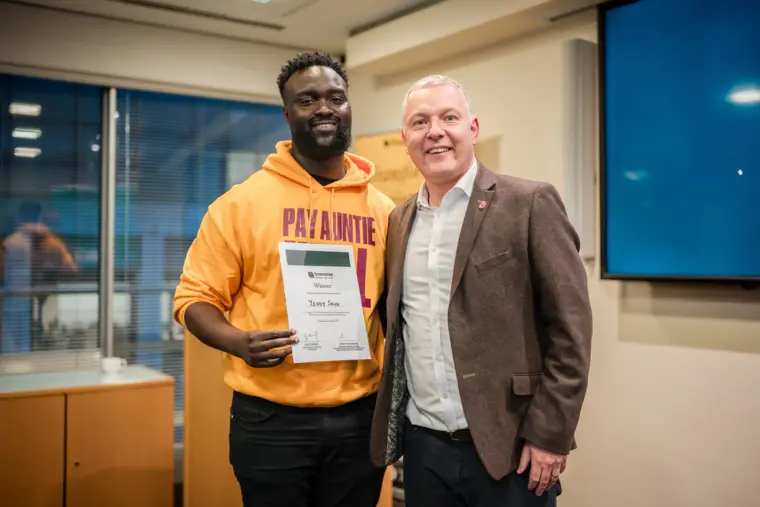 A founder and programme representative pose with a certificate.
