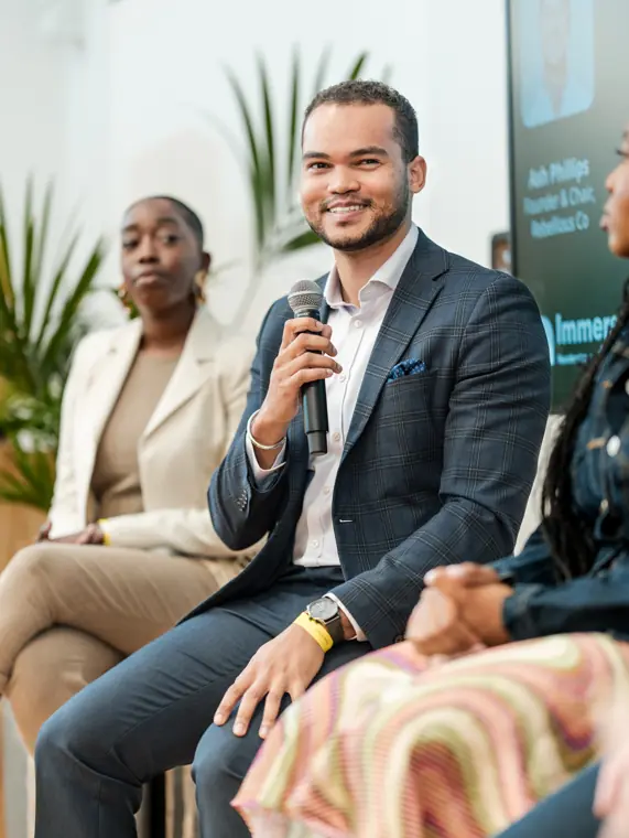 A panellist speaks with a microphone.