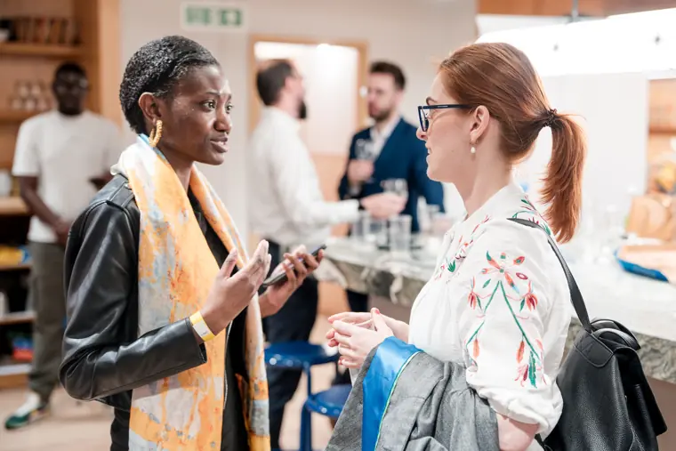 Two guests talk in the networking space.