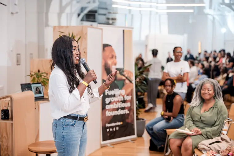 A speaker engages the seated audience.