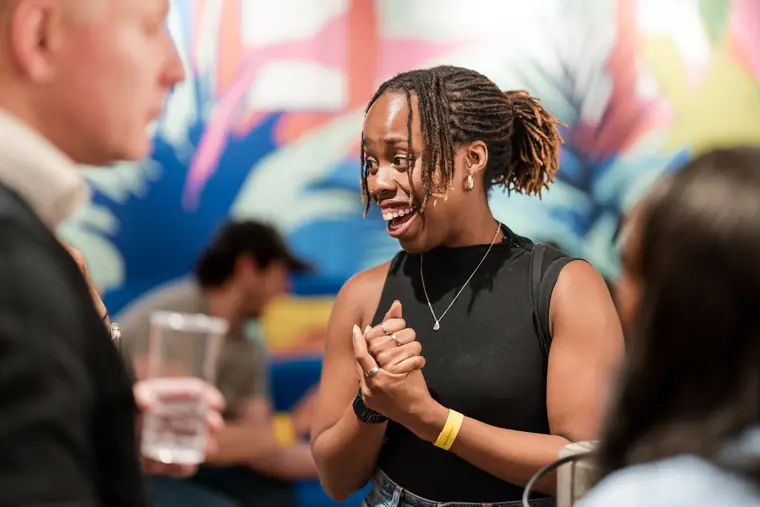A guest laughs with another attendee.
