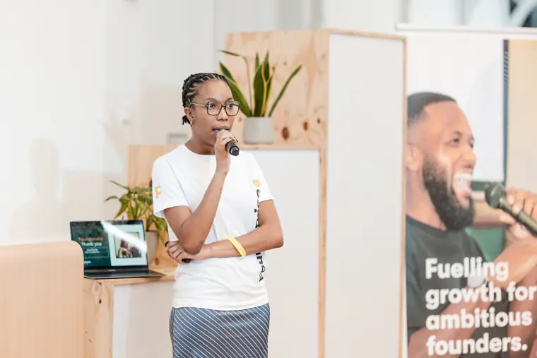 A founder speaks in front of the event display.