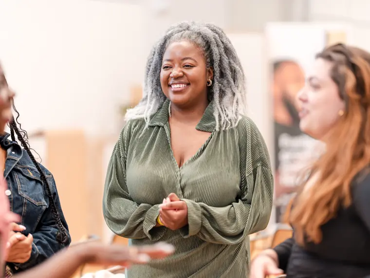 A guest smiles while talking to another attendee.