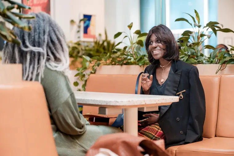 A guest meets another attendee at a table.