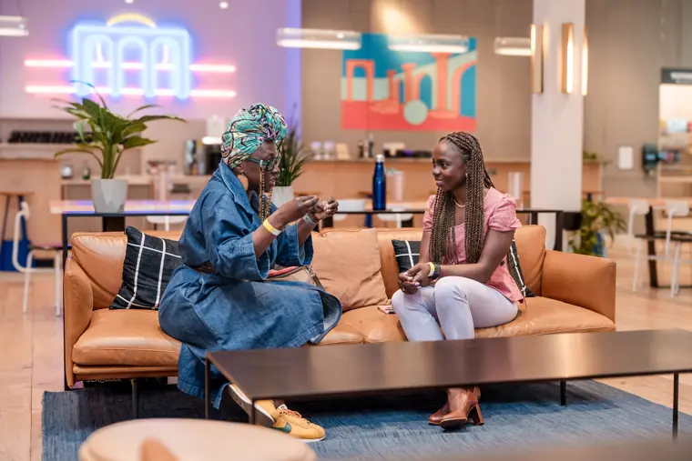 Two guests talk in a quiet corner of the venue.