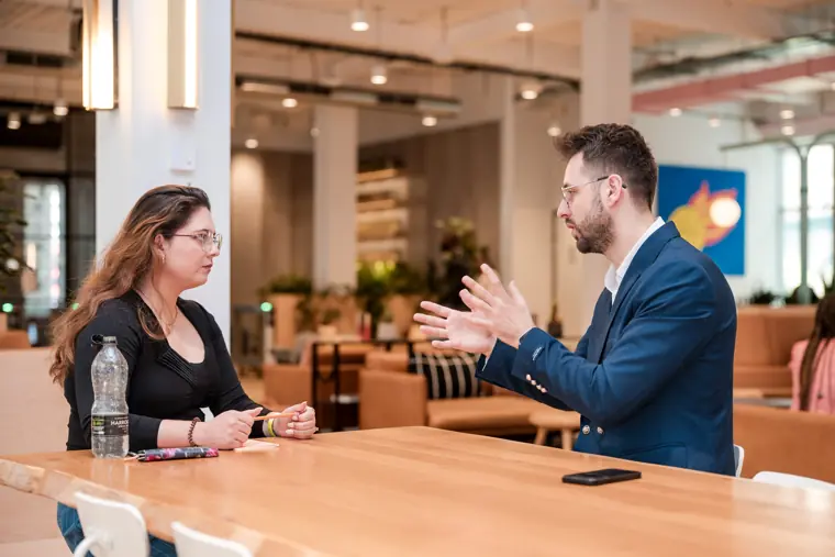 A mentor and founder exchange ideas across a table.