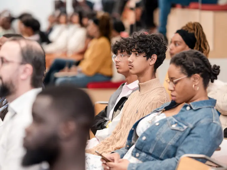 Guests listen from the front rows.