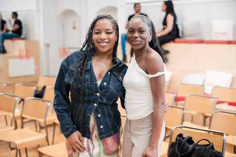 Two attendees smile together at the venue.