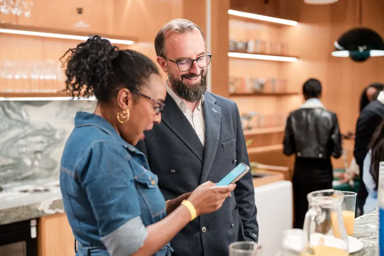 Two attendees talk over a phone during the break.