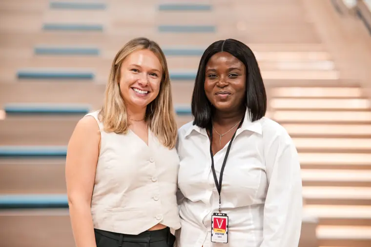Two attendees pause for a portrait by the stairs.