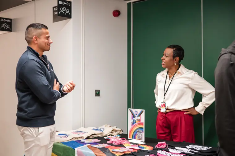 An attendee speaks with a founder at the table.