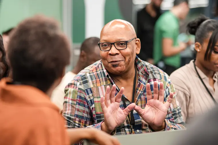 An attendee raises a hand during a discussion.