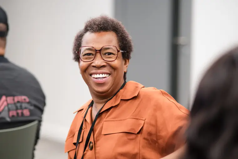 A guest smiles while listening to the speakers.